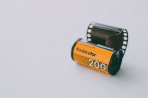 Film roll of Kodak Kodacolor 200 with a clean, minimalist background, showcasing vintage photography equipment.