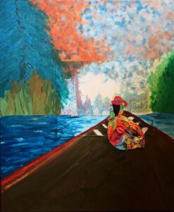 A woman in a bright colored dress holding her hat floats along on the bow of a boat.